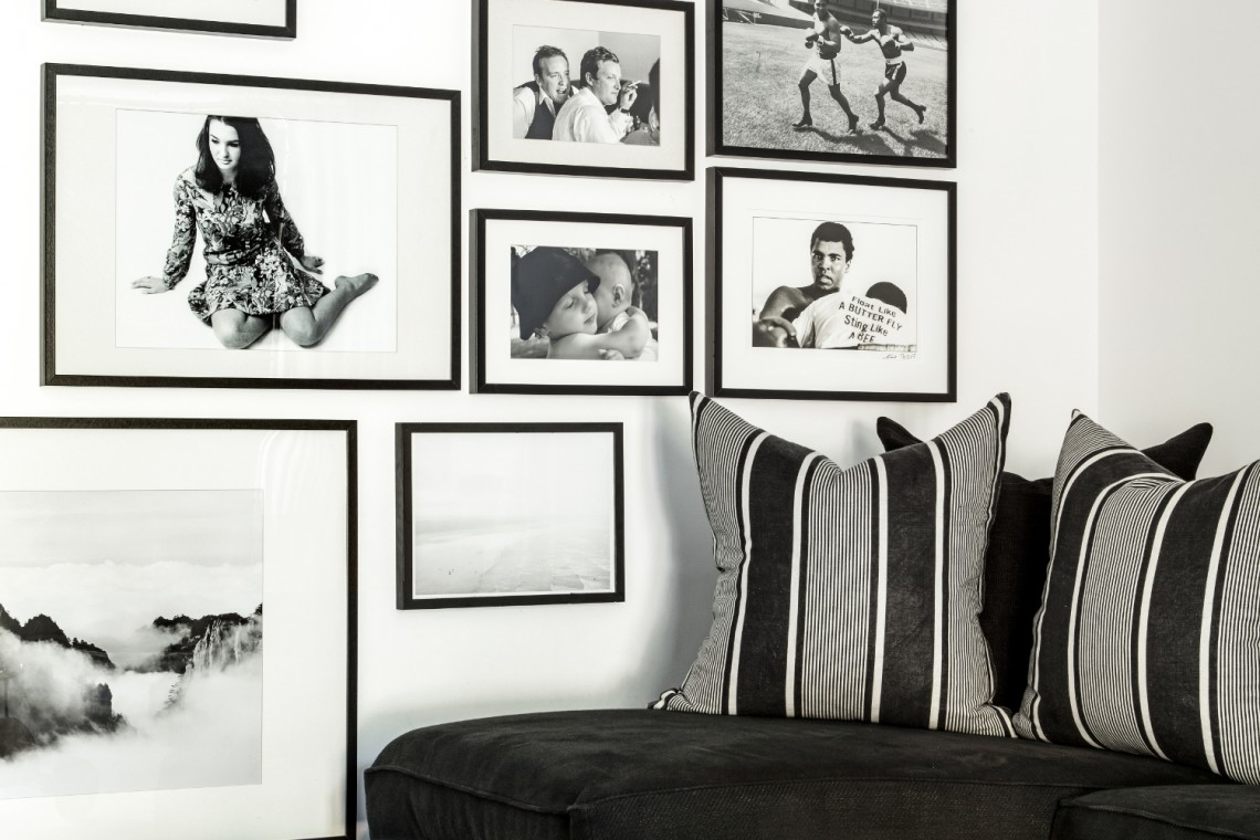 Black and white gallery wall artwork in a family playroom above a built-in daybed.