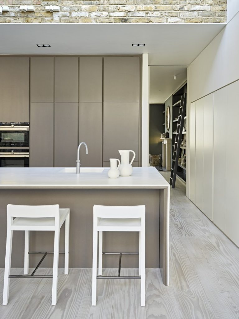 Contemporary kitchen in a London townhouse with a stone island and bespoke cabinetry.