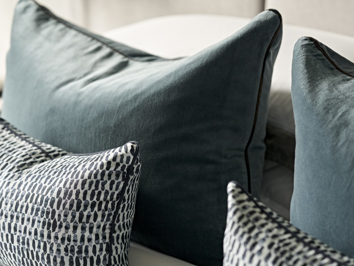 Textural cushion detail in a contemporary London bedroom featuring layered fabrics and a restrained, modern colour palette