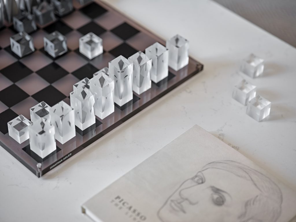 Crystal chess set styled on a marble coffee table in Surrey Residence sitting room.